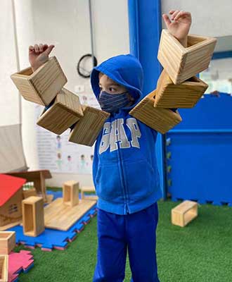Criança explorando peças de madeira - Educação Infantil Uniepre