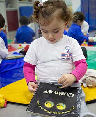 Criança explorando livro - Educação Infantil Uniepre