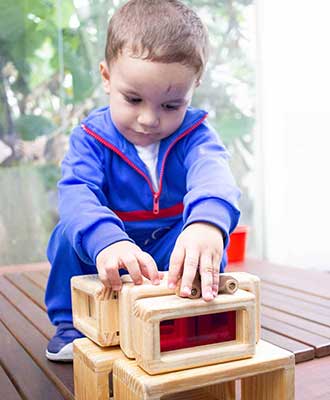 Criança montando objetos de madeira - Educação Infantil Uniepre