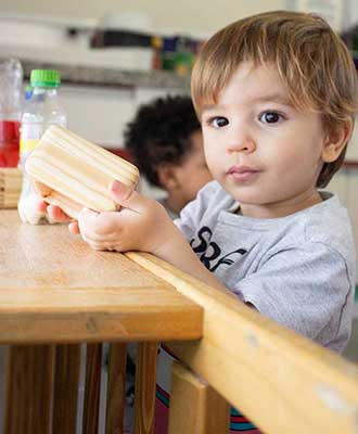 Criança concentrada explorando materiais - Educação Infantil Uniepre
