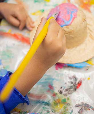 Criança pintando elemento junino - Educação Infantil Uniepre
